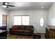 Bright living room with a comfortable sofa, window with blinds, and wood-look floors at 968 W Breckenridge Ave, Gilbert, AZ 85233