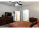Comfortable main bedroom with carpet floors and furniture including a large television at 968 W Breckenridge Ave, Gilbert, AZ 85233