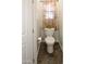 Small water closet with floral valance, white toilet, and brown tile flooring at 968 W Breckenridge Ave, Gilbert, AZ 85233