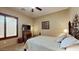 Spacious bedroom with a large bed, dresser, and window with shutters at 11454 N 87Th Pl, Scottsdale, AZ 85260