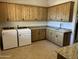 Well-equipped laundry room with wooden cabinets, granite countertops, and modern washer and dryer at 11454 N 87Th Pl, Scottsdale, AZ 85260