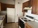 Small kitchen with wooden cabinets, stove and refrigerator at 1508 E Todd E Dr, Tempe, AZ 85283