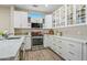 Modern kitchen with white cabinets, glass-front cabinets, and stainless steel appliances at 15996 W Mesquite Ct, Surprise, AZ 85374