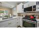 Modern kitchen with white cabinets, stainless steel appliances and a tiled backsplash at 15996 W Mesquite Ct, Surprise, AZ 85374
