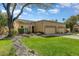 Two-car garage and front yard with mature tree and rock landscaping at 19504 N 88Th Dr, Peoria, AZ 85382
