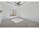 Minimalist bedroom with neutral carpet, ceiling fan, and large window allowing for natural light at 28484 N 91St Ave, Peoria, AZ 85383