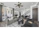 Open-concept living room with modern decor, featuring a ceiling fan, staircase, and dining area at 28484 N 91St Ave, Peoria, AZ 85383