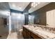 Modern bathroom featuring a double sink vanity with granite countertop, tile flooring, and shower with curtain at 3126 E San Angelo Ave, Gilbert, AZ 85234