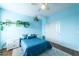 Bright bedroom featuring light blue walls, indoor plants, ceiling fan and a comfortable-looking bed with white nightstands at 3126 E San Angelo Ave, Gilbert, AZ 85234