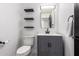 Clean bathroom with gray vanity, marble floor, and floating shelves at 36039 N 58Th St, Cave Creek, AZ 85331