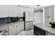 Contemporary kitchen with white cabinets, marble floors, stainless appliances, and bar seating at 36039 N 58Th St, Cave Creek, AZ 85331