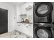 Laundry room features stacked washer/dryer and white cabinetry, stylish marble floors at 36039 N 58Th St, Cave Creek, AZ 85331