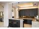Modern wet bar with dark cabinetry and marble countertops at 36420 N 105Th Pl, Scottsdale, AZ 85262