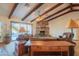 Living room with stone fireplace, wood beams, and access to patio at 40411 N 69Th Pl, Cave Creek, AZ 85331