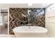 Bathroom featuring a large soaking tub and a mosaic tile feature wall at 4401 E Sunset Dr, Phoenix, AZ 85028