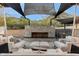 Outdoor fireplace and seating area with shade sails at 4401 E Sunset Dr, Phoenix, AZ 85028