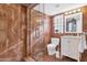 Bathroom with glass shower, marble tile, and white vanity at 4601 E Solano Dr, Phoenix, AZ 85018