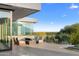 Wide patio with comfortable seating and a glass barrier overlooking desert landscape at 6149 E Indian Bend Rd, Paradise Valley, AZ 85253