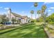 Expansive backyard featuring a lush lawn, tall palm trees, and a charming white home with a chimney at 6235 E Montecito Ave, Scottsdale, AZ 85251