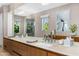 Bathroom detail showing long countertop with dual sinks and view to a large mirror and shower at 6235 E Montecito Ave, Scottsdale, AZ 85251