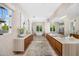 Spacious primary bathroom with dual vanities, soaking tub, and ample natural light from surrounding windows at 6235 E Montecito Ave, Scottsdale, AZ 85251