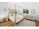 Sunlit bedroom with a four-poster bed, a decorative rug, and white walls at 6235 E Montecito Ave, Scottsdale, AZ 85251