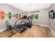 Bright workout room with hardwood floors features modern exercise equipment and unique Campbell's Soup skateboard art at 6235 E Montecito Ave, Scottsdale, AZ 85251