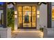 Modern front entry showcases a large glass and steel door, offering a glimpse into the home at 6235 E Montecito Ave, Scottsdale, AZ 85251