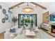 Bright and airy living room featuring vaulted ceilings, wood beams and large sliding glass doors at 6235 E Montecito Ave, Scottsdale, AZ 85251