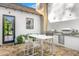 Outdoor kitchen space featuring modern appliances, a built-in grill, pizza oven, and a cozy dining area for four at 6235 E Montecito Ave, Scottsdale, AZ 85251