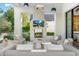 Inviting outdoor living area with a stone fireplace, plush seating, and lush landscaping at 6235 E Montecito Ave, Scottsdale, AZ 85251