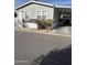Mobile home exterior features gray siding, white trim, and carport at 625 W Mckellips Rd # 115, Mesa, AZ 85201