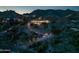 Night view of a luxurious home nestled into the mountainside with landscape lighting at 7060 N Hillside Dr, Paradise Valley, AZ 85253