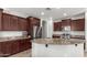 Spacious kitchen featuring dark wood cabinets, granite countertops, and stainless steel appliances at 739 E Lovebird Ln, Gilbert, AZ 85297