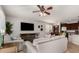 Living room with sectional sofa, hardwood floors, and a large TV at 739 E Lovebird Ln, Gilbert, AZ 85297