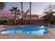 Inviting kidney-shaped pool with stone coping, at dusk at 739 E Lovebird Ln, Gilbert, AZ 85297