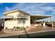 Single-wide manufactured home with covered porch and desert landscaping at 7750 E Broadway Rd # 125, Mesa, AZ 85208