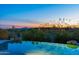 Stunning backyard pool reflecting the colorful sky during sunset, surrounded by desert vegetation at 9045 E Chino Dr, Scottsdale, AZ 85255