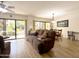 Open-concept living room with wood floors and sliding glass door access to courtyard at 10330 W Thunderbird Blvd # A125, Sun City, AZ 85351