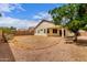 View of the backyard featuring a covered patio, desert landscaping, and privacy walls at 12937 W Highland Ave, Litchfield Park, AZ 85340
