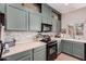 Kitchen features green cabinets and modern appliances at 13157 N 87Th Dr, Peoria, AZ 85381