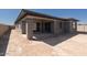 Exterior view of the backyard featuring a covered patio, stucco walls, and dark-trimmed windows at 1436 E Cherrywood Pl, Chandler, AZ 85249