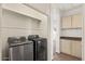 Laundry room featuring stainless steel washer and dryer and custom cabinetry at 15858 S 11Th Pl, Phoenix, AZ 85048