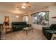 Living room with tiled floors, leather furniture, and large windows at 16167 W Quail Creek Ln, Surprise, AZ 85374