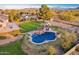 Aerial photo highlights a backyard pool area with an adjacent outdoor living space, mature trees, and lush lawn at 17645 E Stacey Rd, Queen Creek, AZ 85142