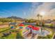 Inviting pool area featuring a rock waterfall, outdoor kitchen, and lounge chairs, all with a mountain view at 17645 E Stacey Rd, Queen Creek, AZ 85142