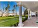 Inviting backyard view featuring mature palm trees and a covered porch at 1859 N Val Vista Dr, Mesa, AZ 85213