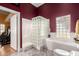 Bright bathroom with glass block shower, white tub, vanity with oak cabinets, and a view to a work out room at 1859 N Val Vista Dr, Mesa, AZ 85213