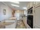 Galley kitchen with light wood cabinets, granite countertops, and stainless steel appliances at 215 N Power Rd # 440, Mesa, AZ 85205