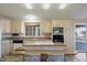 Open kitchen with island, light wood cabinets, and stainless steel appliances at 215 N Power Rd # 440, Mesa, AZ 85205